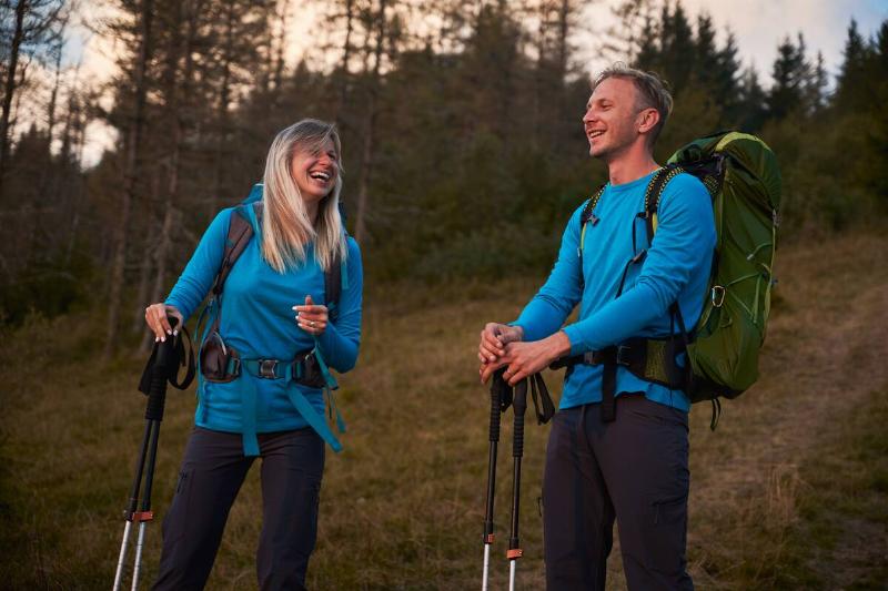 A man and woman walking with hiking poles. 