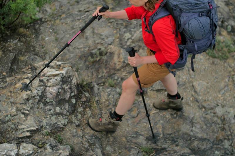 Aerial view of a hiker using hiking poles while walking across a rock. 
