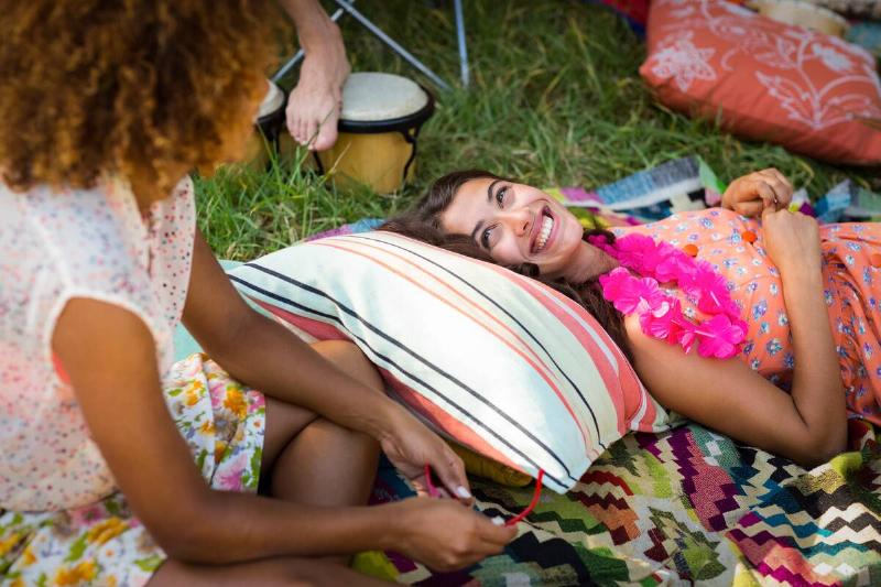 Woman laying on a pillow at a campsite. 