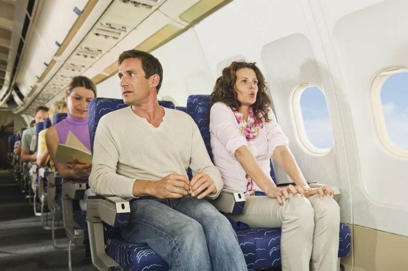 Two passengers sitting on a plane. 