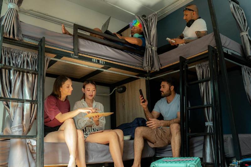 A group of travelers relaxing in hostel bunk beds. 