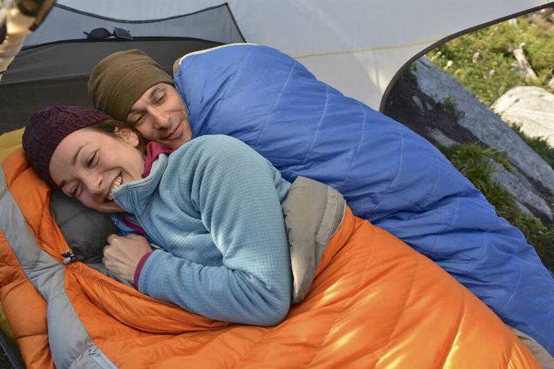 Man and woman sleeping in sleeping bags in a tent. 