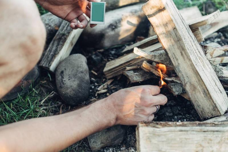 A person lighting a fire on fire with a match.  