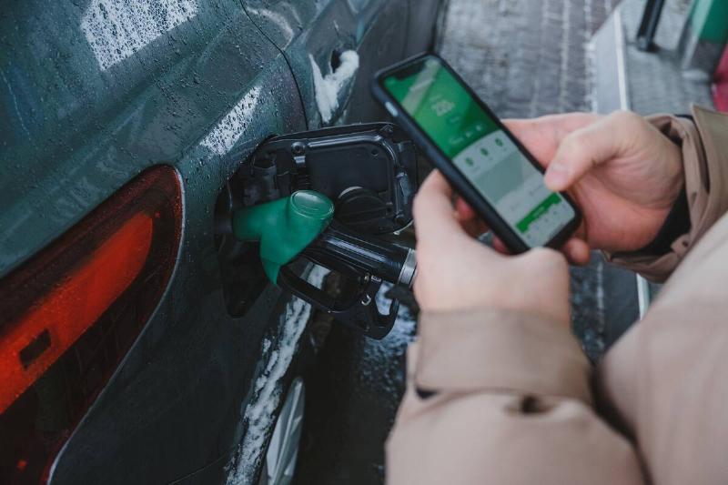 Man fills up car with gas and pays with his smartphone.