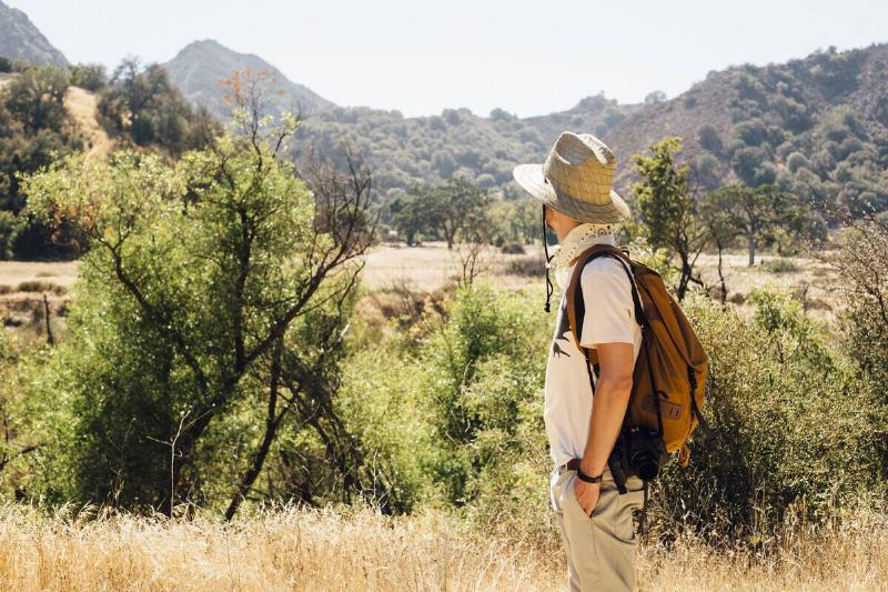 Man hiking looking away at view of mountains.