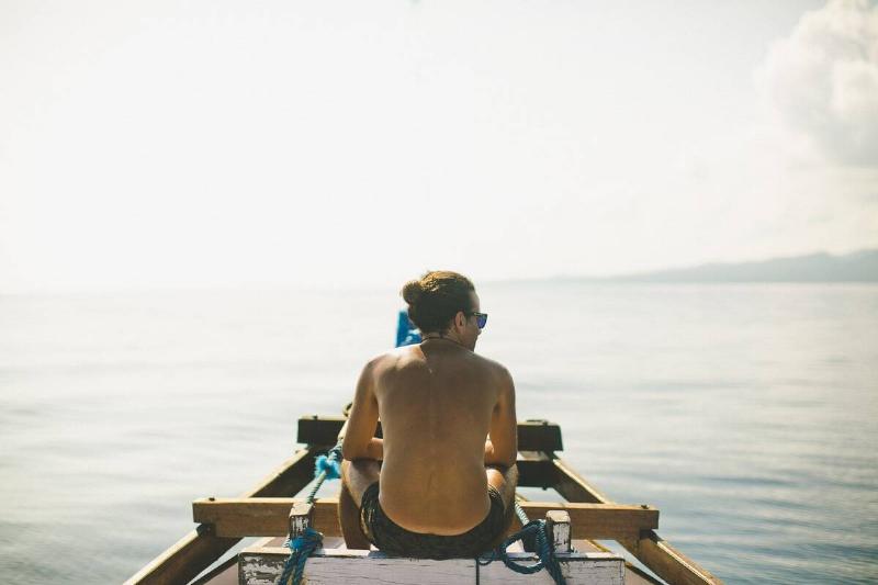 Person sitting on boat, view from behind. 