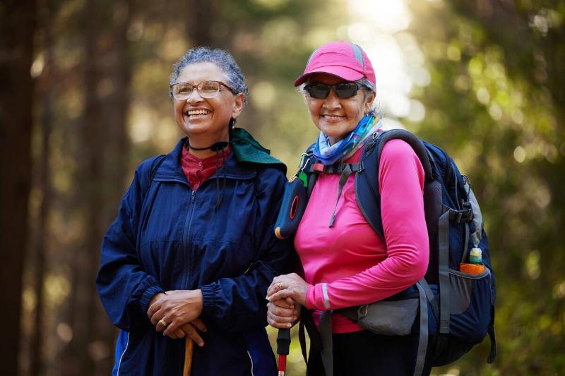 Two senior women in a forest hiking. 