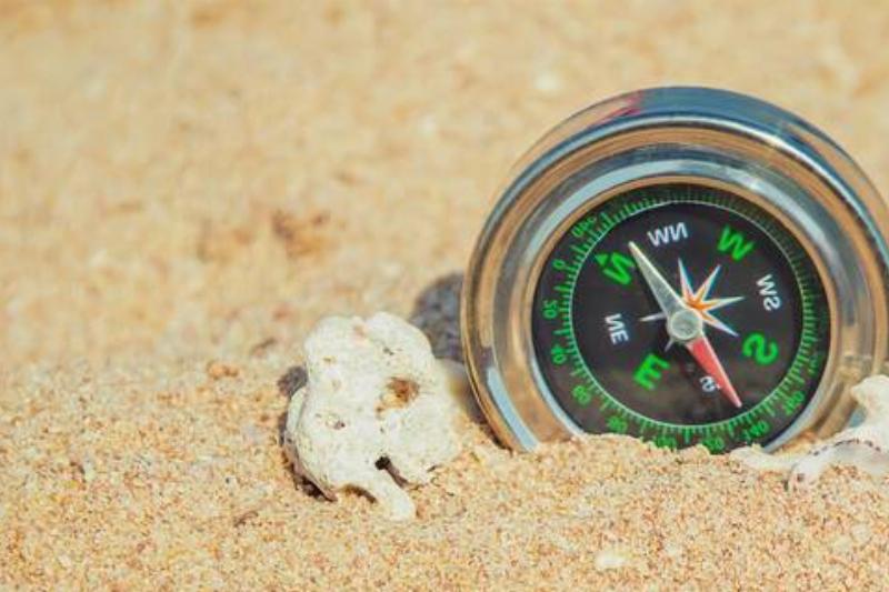 A compass buried in sand. 