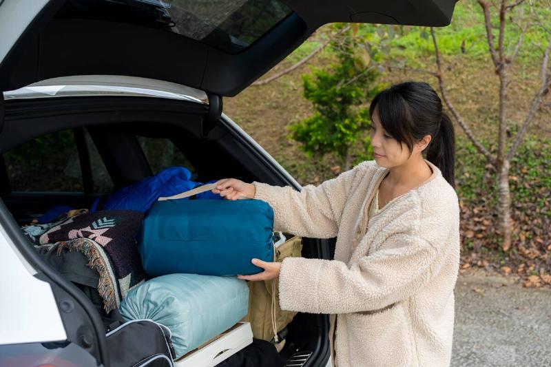 A woman packing the trunk of her car for camping. 