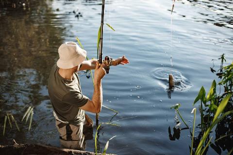 A young fisherman catching fish in a river. 