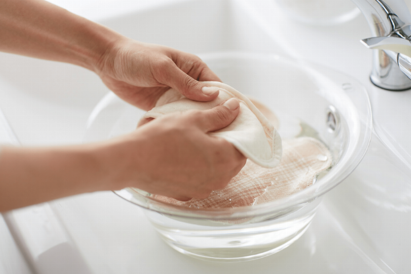 A bowl of water and a cloth in a sink. 