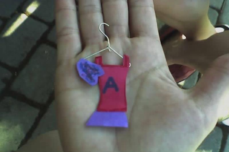 Small doll clothes on a hanger. 