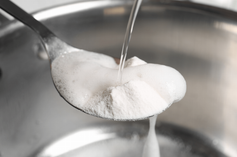 Vinegar poured into baking soda on a spoon. 
