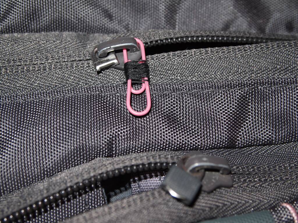 A pink paper clip used as a zipper pull. 