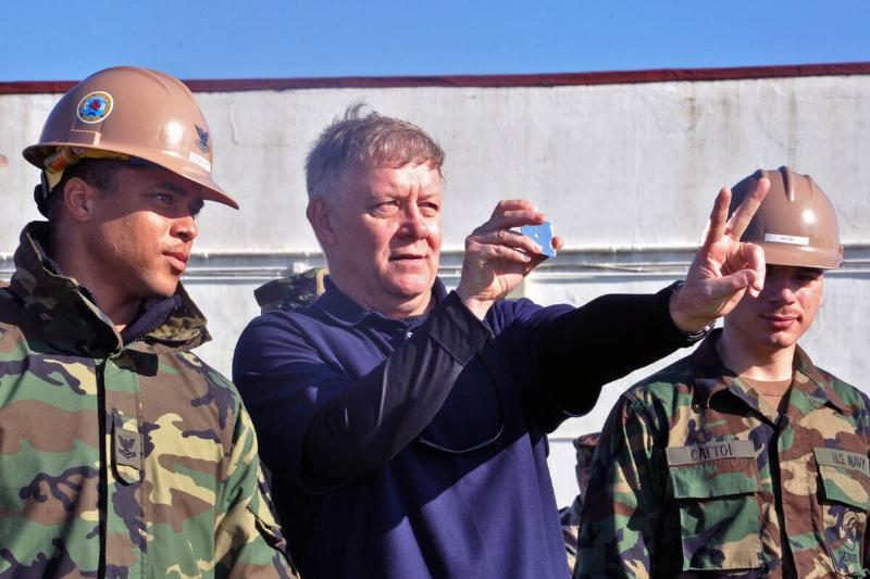 Mike Dozier, center, senior personnel recovery analyst for Commander, U.S. Naval Forces Europe-Africa, demonstrates how to properly signal.
