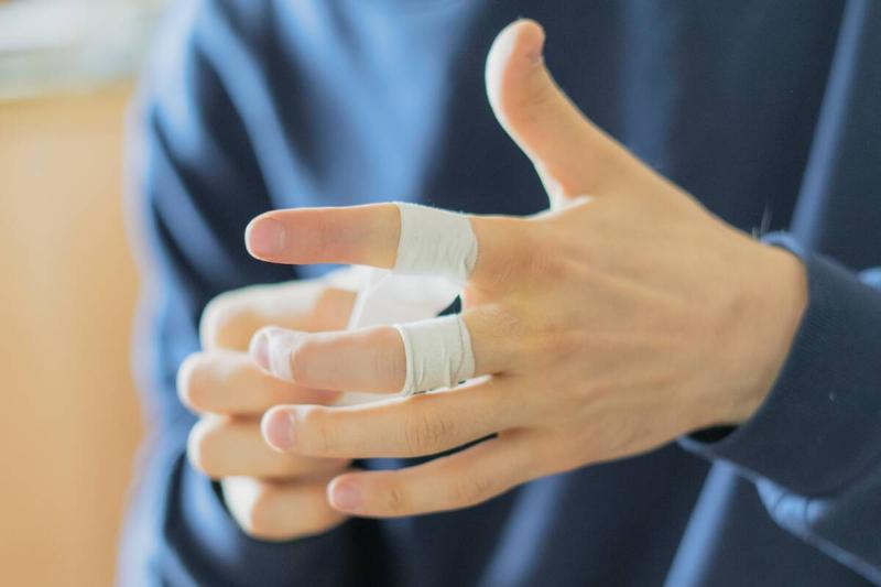 Close up athlete wrapping tape on their finger.