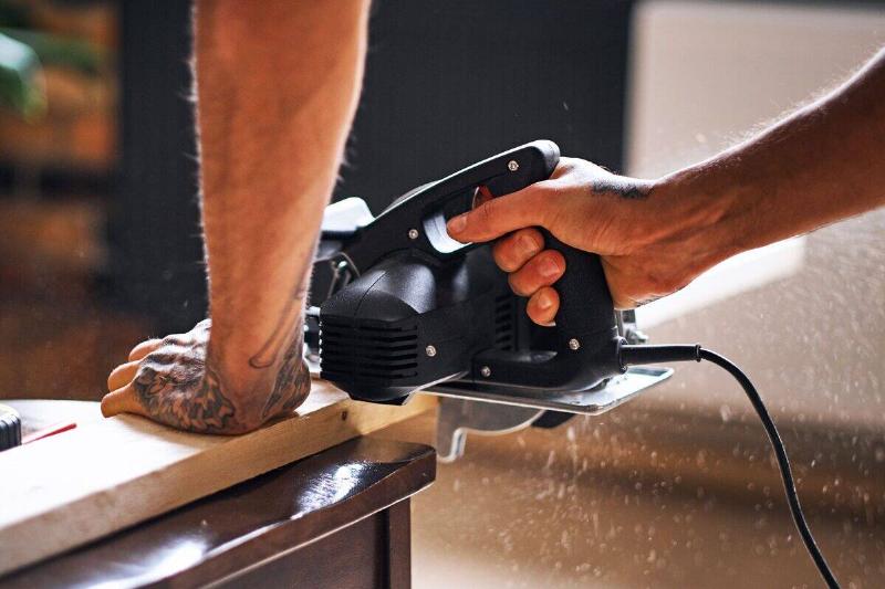 A person using a circular hand saw. 