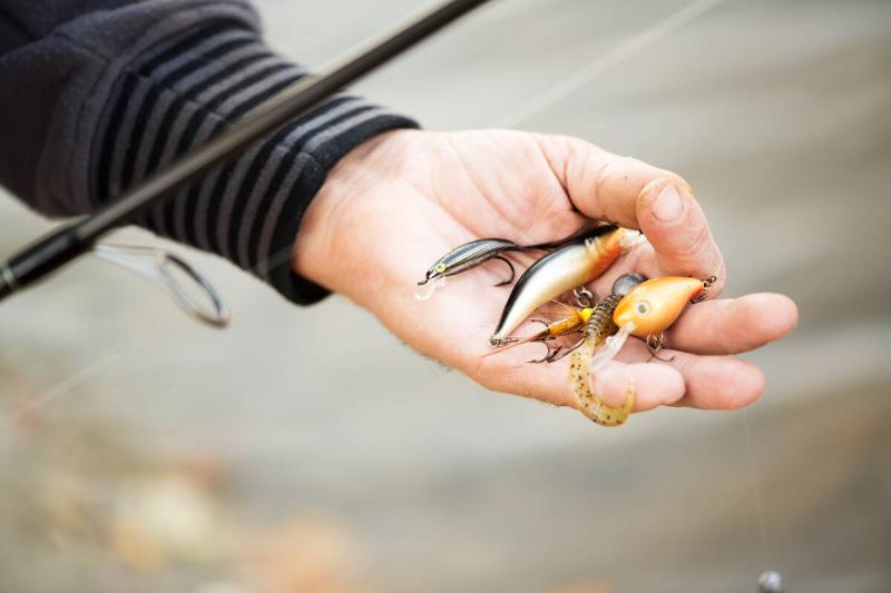Fisherman holding many Fishing lures..