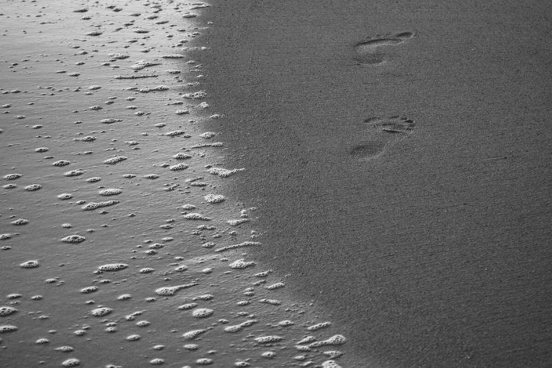 Footprints in sand on a beach. 