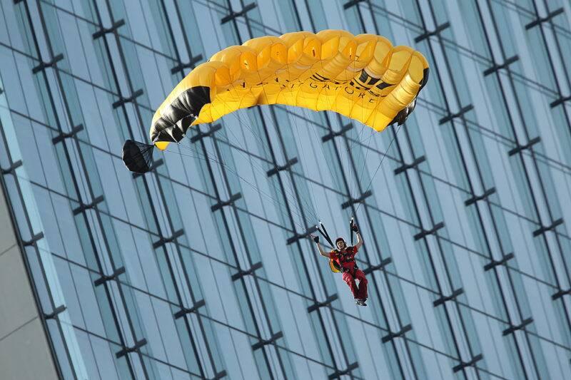 A BASE jumper slowly makes his descent after jumping off a skyscraper in Marina Bay Sands, Singapore.