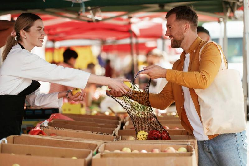 A man buying apples from a farmer's market. 