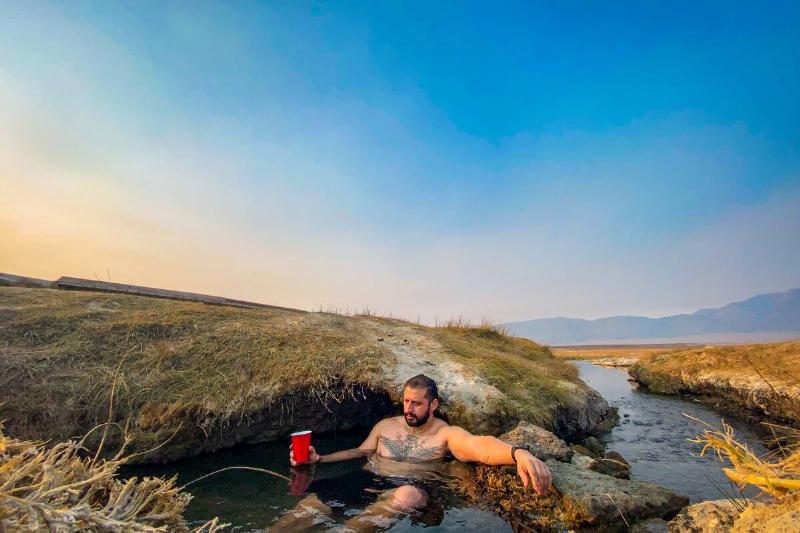 Man in hot springs with red solo cup. 