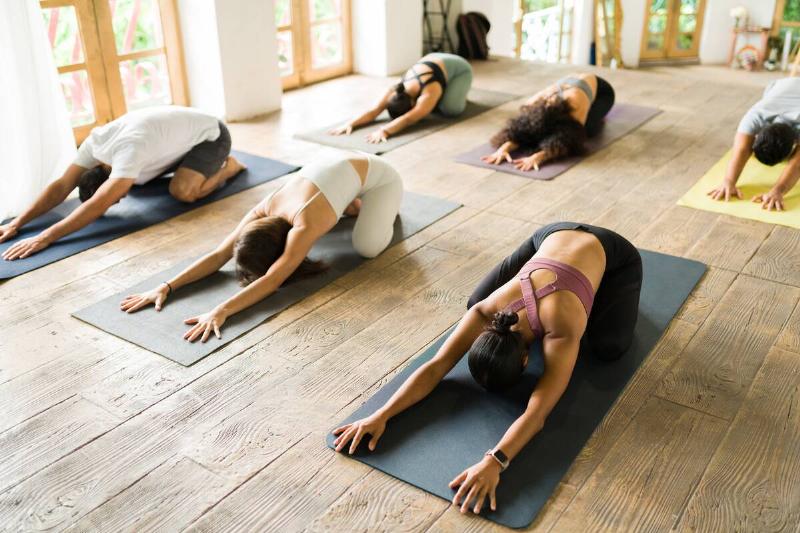 A group of people in a fitness class stretching. 