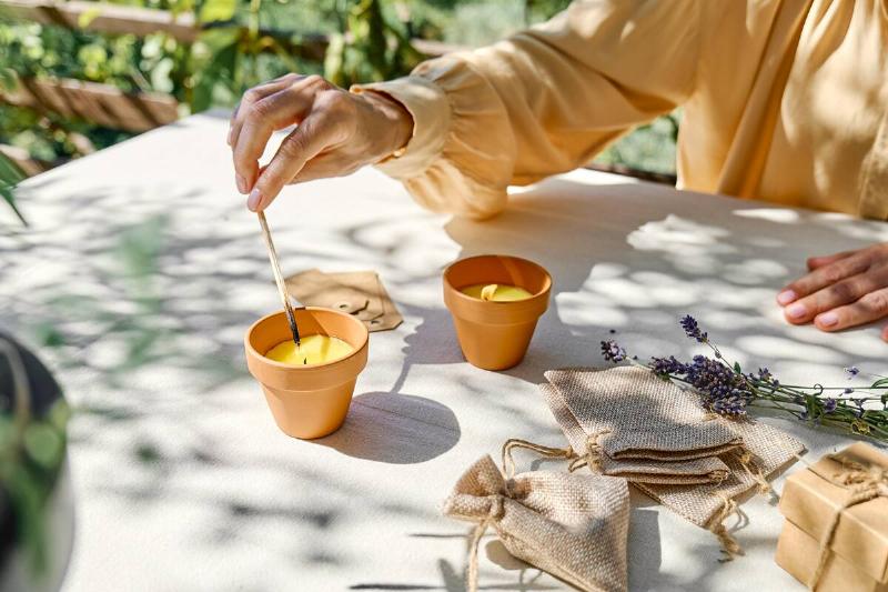 Female hand lighting candle with match, outdoors