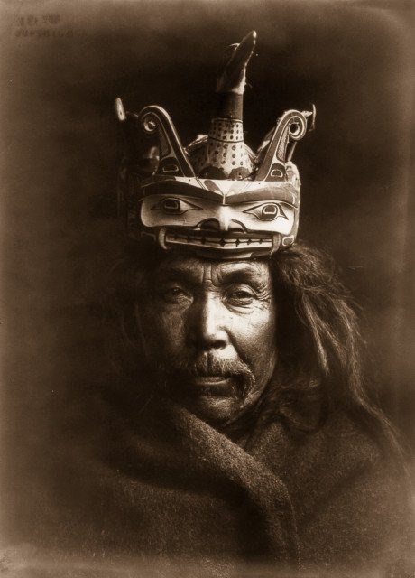 A Kwakiutl man wearing a mask depicting a man transforming into a loon.1914