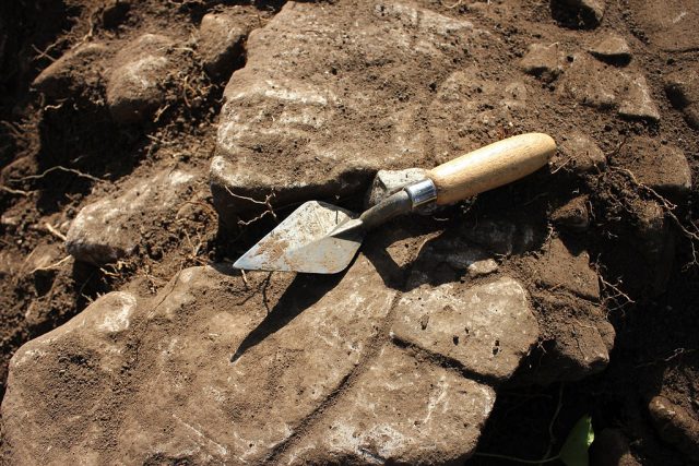 Standard archaeology trowel used in British Archaeology. Taken on excavations at Caerwent. – Author: HeritageDaily – CC BY-SA 3.0