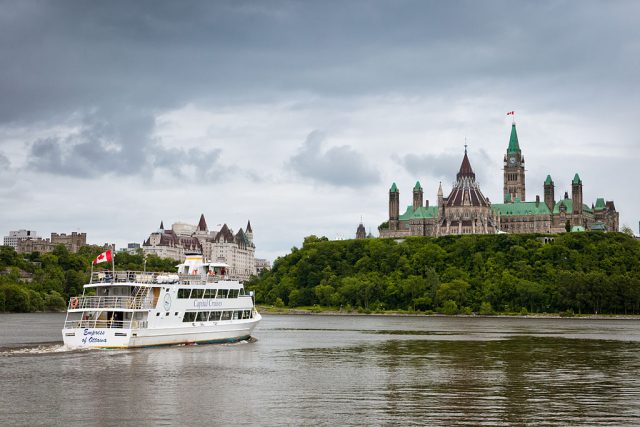 A ferry/cruise ship sails by the back of the Canadian Parliamentary Building – Author: Benson Kua – CC BY-SA 2.0