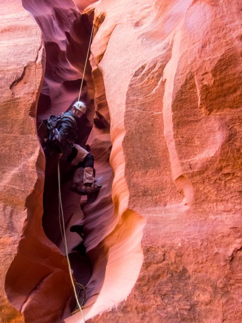 A canyoneer rappels into a slot canyon in Utah. Photo Credit