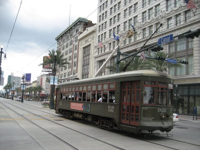 Canal Street, New Orleans. 1920s Pearly Thomas streetcar 922 heads out past the Maison Blanche Building. – Author: Infrogmation of New Orleans – CC BY-SA 3.0