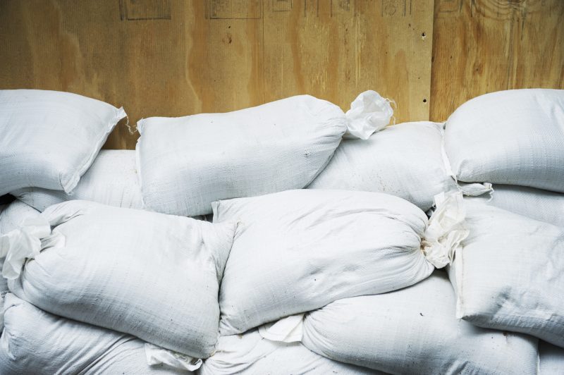 Sand bags piled up against protective plywood.