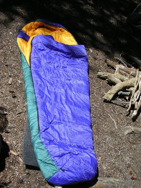 A mummy bag, so named because it has an insulated hood which keeps the head warm. A foam sleeping pad can be seen underneath the sleeping bag