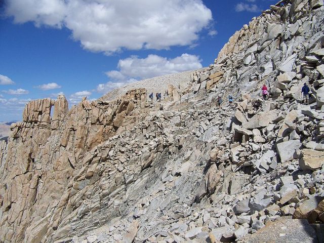 Hikers approach the southern end of the John Muir Trail. The Mount Whitney summit plateau can be seen in the distance. Author: Cullen328- CC BY 3.0
