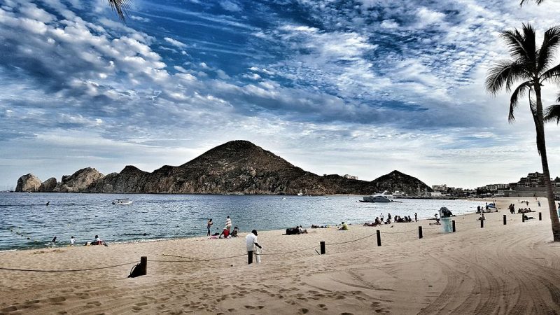 Medano is the main beach of Cabo San Lucas, pictured here with Land’s End in the background – Author: Cristo Vlahos – CC BY-SA 4.0