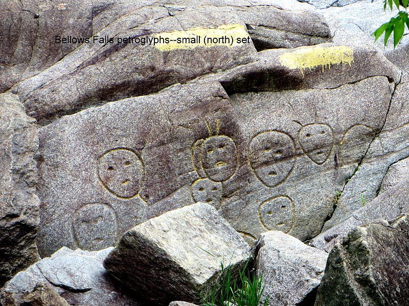 Smaller set of petroglyphs at Bellows Falls, located 35 feet (11 m) south of the bridge. Photo was taken looking east from the road along the shore in the village of Bellows Falls – Author: Pbergstrom – CC BY-SA 3.0