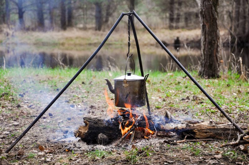 All you need to boil water is a fire and a metal container that can withstand the flames.