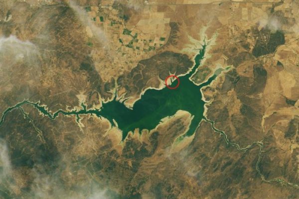 A satellite image of the Valdecanas Reservoir from July. The red ring marks the Dolmen of Guadalperal. NASA Earth Observatory