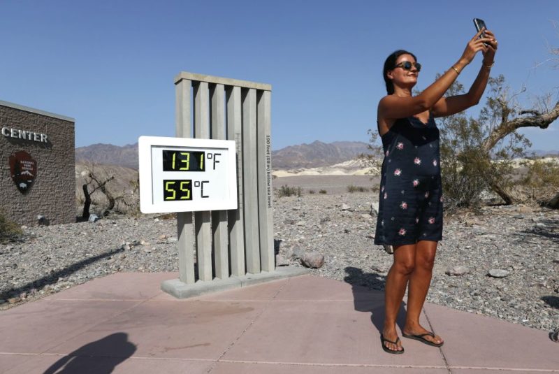 A tourist takes a thermometer picture outside of Death Valley