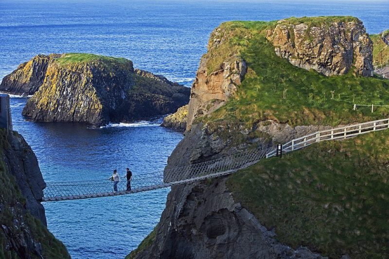 Two people crossing the Carrick-a-Rede Bridge