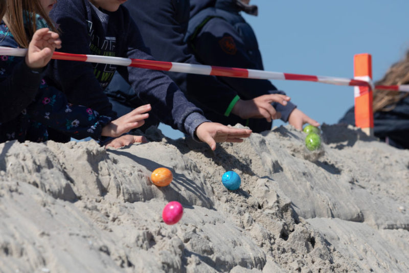 People grabbing Easter eggs of the beach