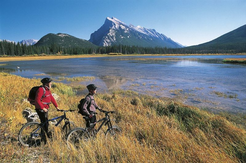 Two cyclists looking out over a body of water