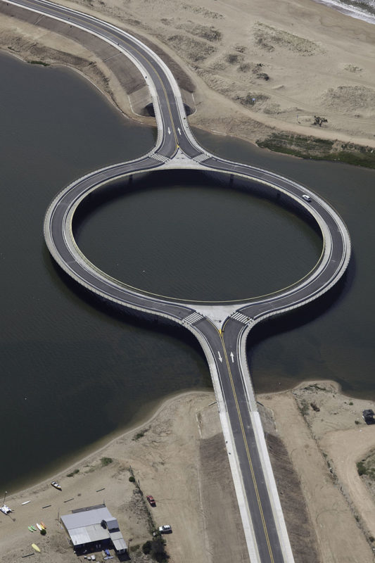 Aerial view of a car driving across the Laguna Garzón Bridge in Laguna Garzón, Uruguay