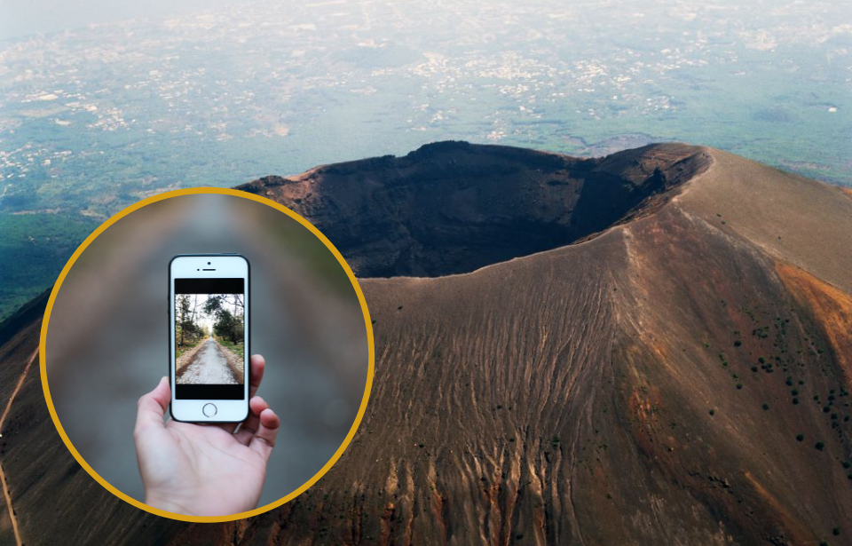 Aerial view of Mount Vesuvius + Hand holding an iPhone