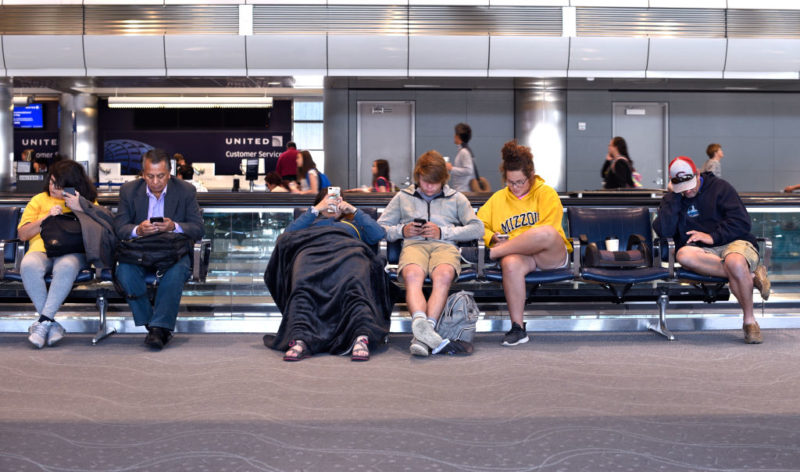 Travelers sitting in an airport terminal