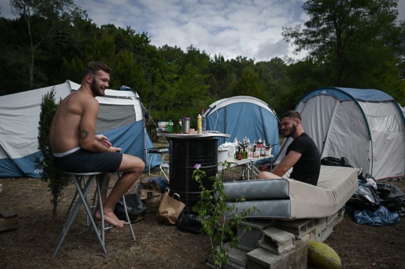Two men sitting at a campsite
