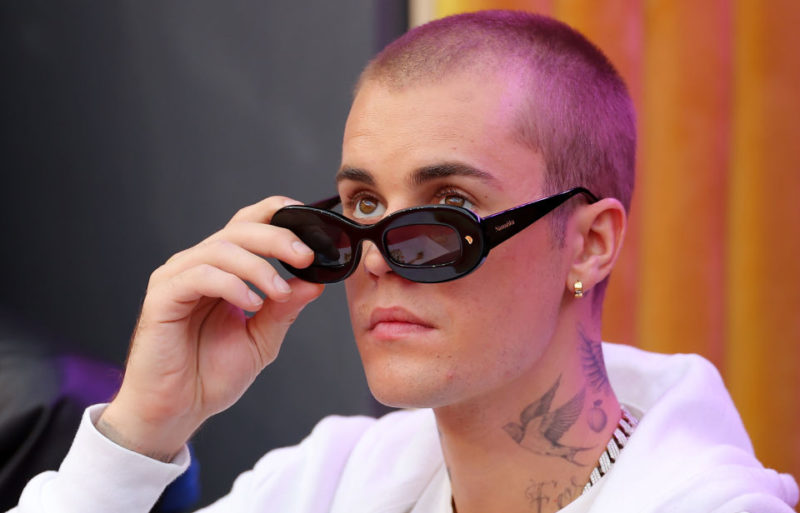Justin Bieber looking over his sunglasses