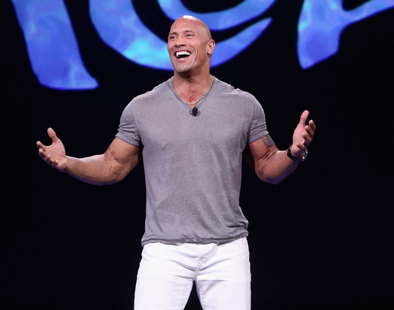 Dwayne "The Rock" Johnson standing with his arms outstretched